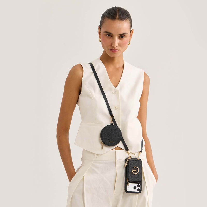 Model wearing a black Custype crossbody wallet phone case with a round pouch