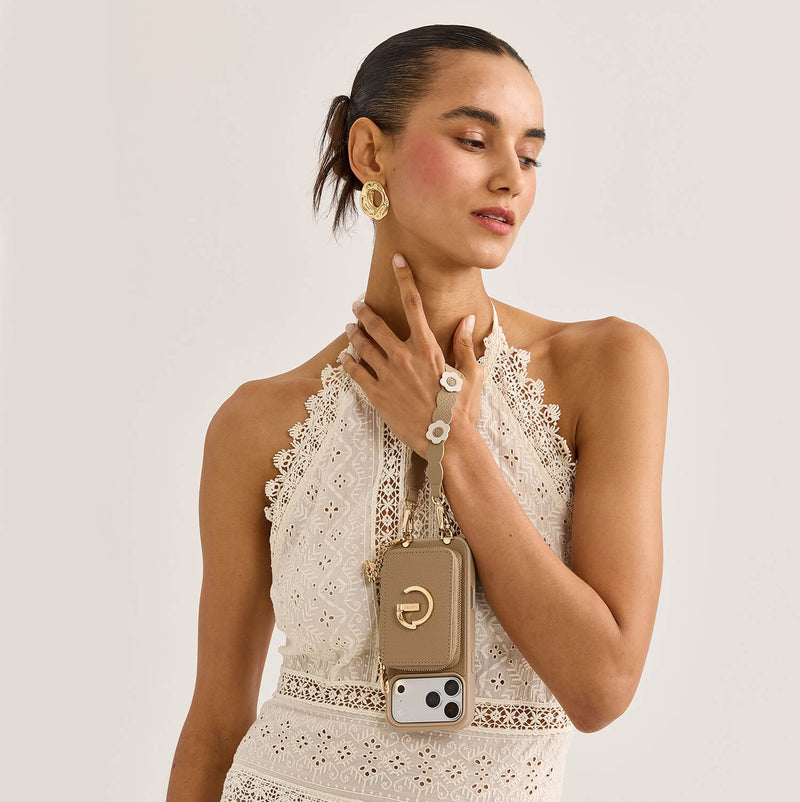 Woman wearing a taupe iPhone 17 Pro Max wallet case with a crossbody strap