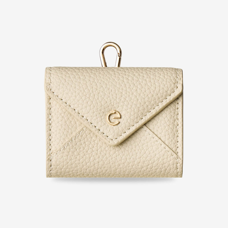 Beige envelope-inspired AirPods pouch with leather finish and detachable gold-tone clip for everyday carry