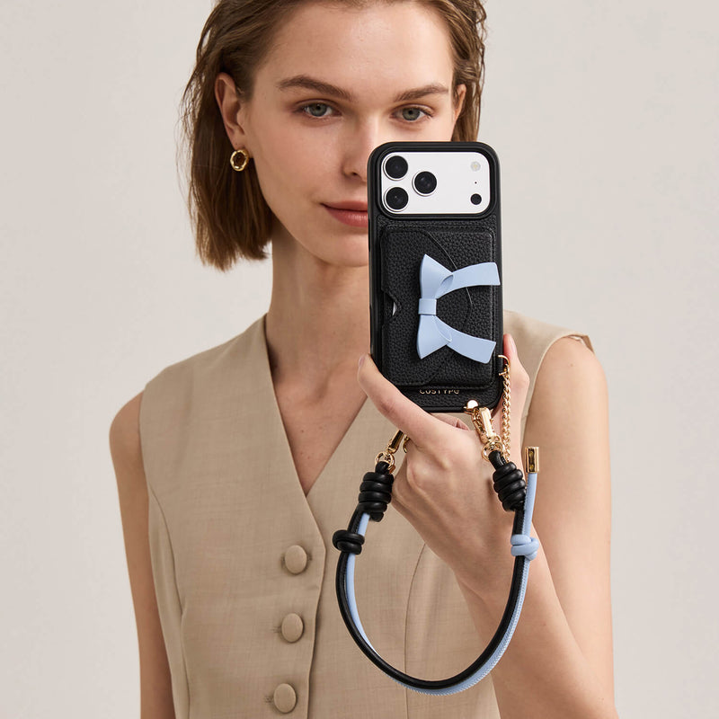 Black magsafe iPhone 18 Pro wallet phone case with bow design, RFID card protection and adjustable wrist strap for stylish everyday carrying
